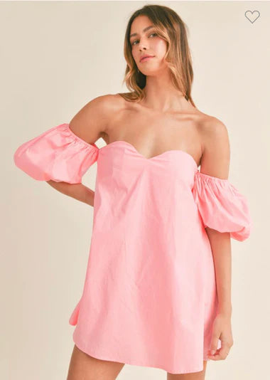 Model wearing a pink off-shoulder dress from Sophie May Boutique, perfect for summer fashion.