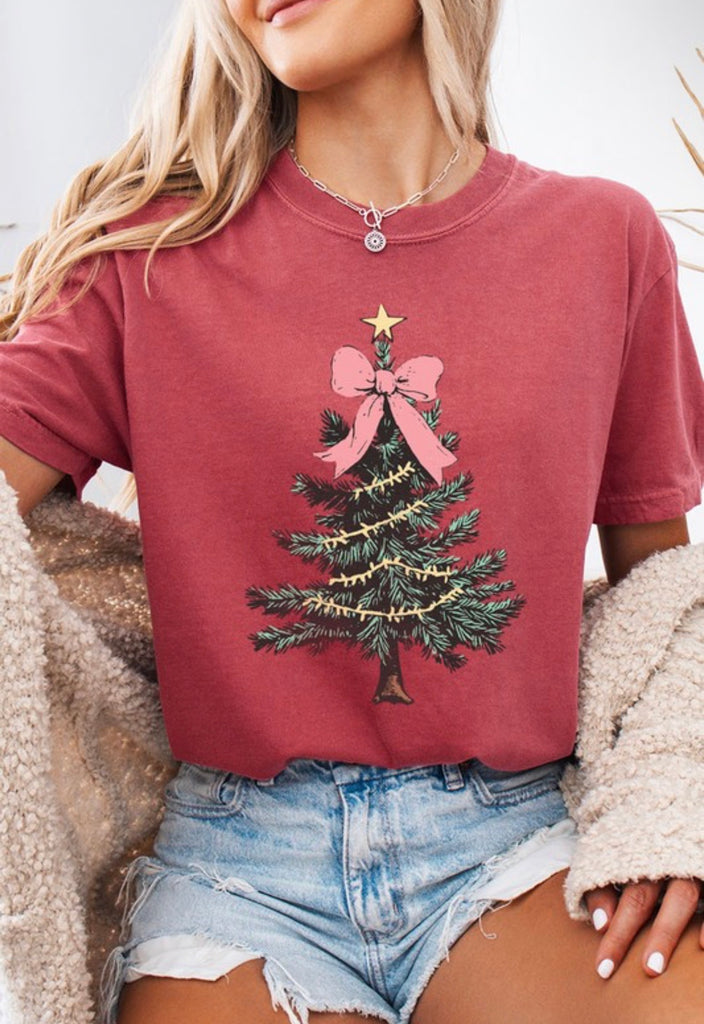 Holiday Coquette Graphic Tee featuring a Christmas tree with a pink bow and golden star, perfect for women’s clothing.